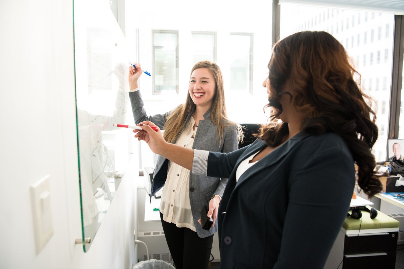 Colleagues planning work at a whiteboard